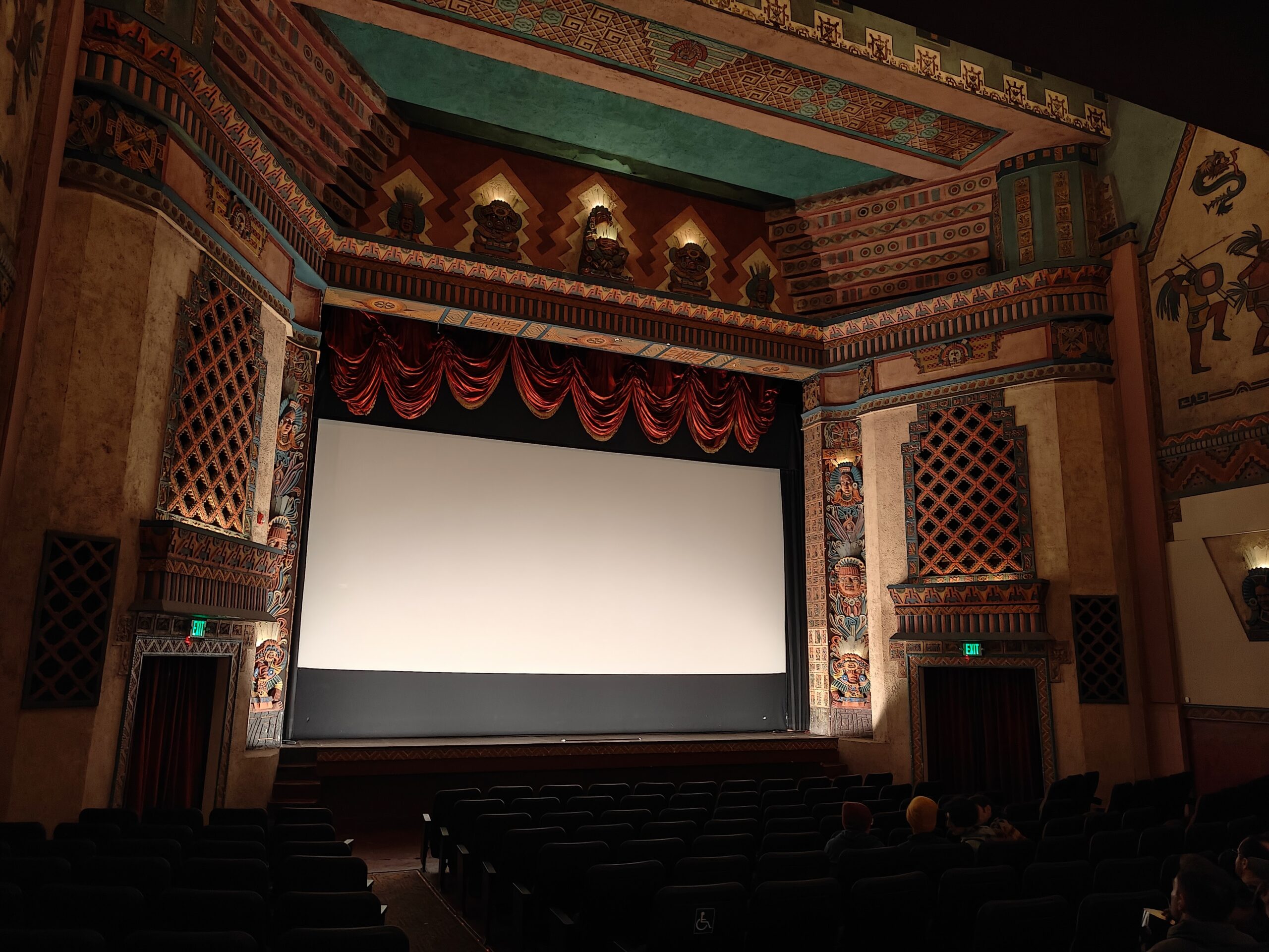 Sala de cine con pantalla grande lista para proyectar una película