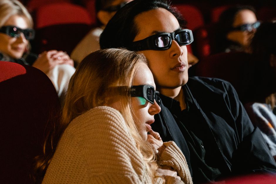 Pareja de espectadores viviendo una experiencia de cine inmersiva en una sala de proyección
