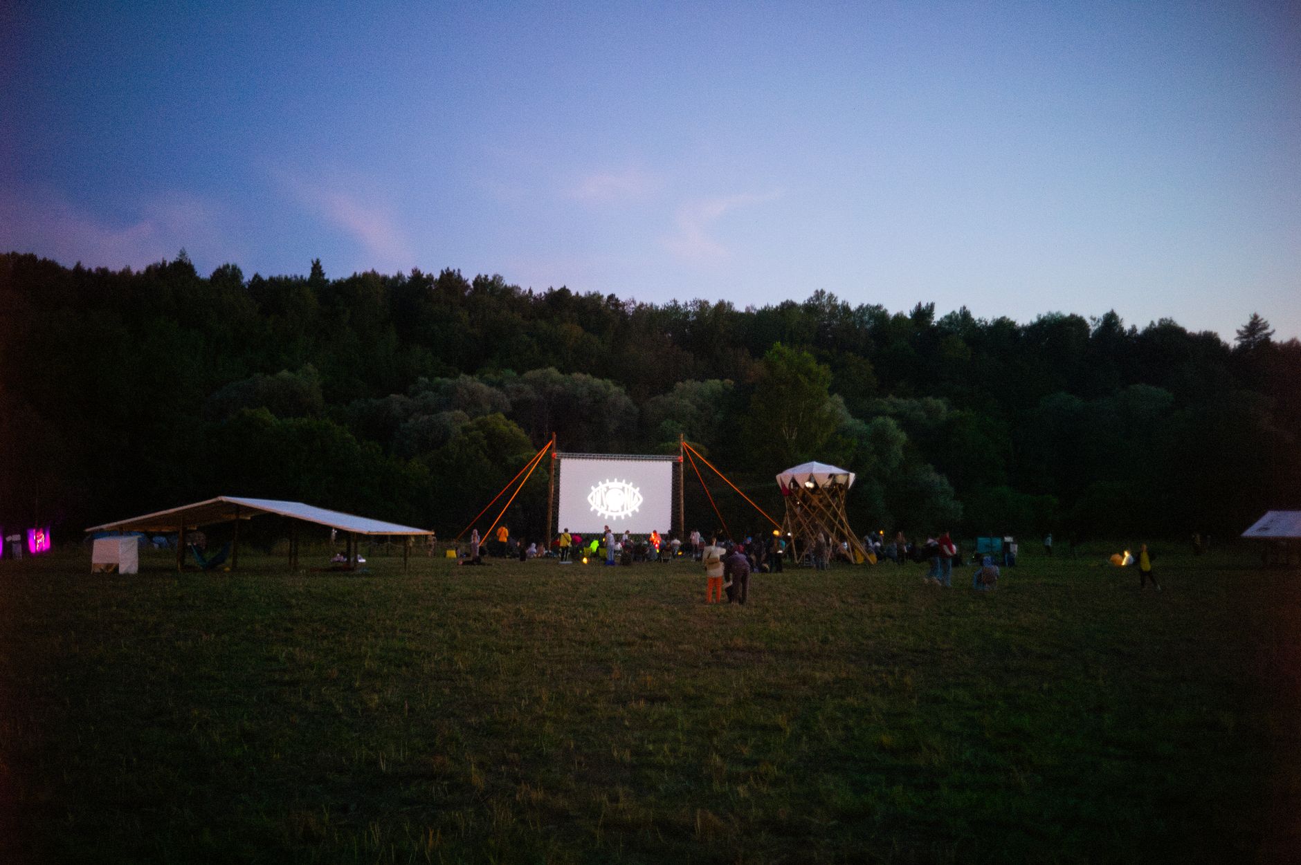 Cine al aire libre al atardecer con la pantalla iluminada, imagen ilustrativa de un festival de cine