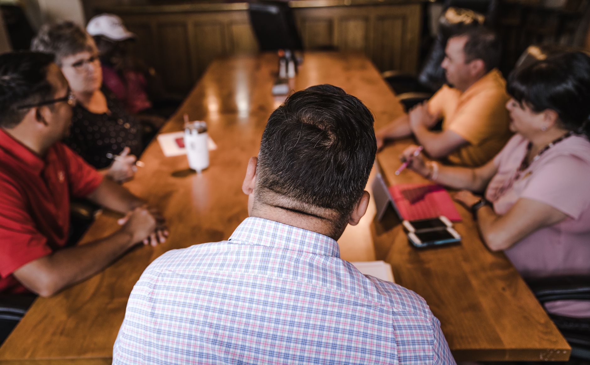 Equipo reunido en torno a una mesa de madera, imagen de referencia de la película A Statement