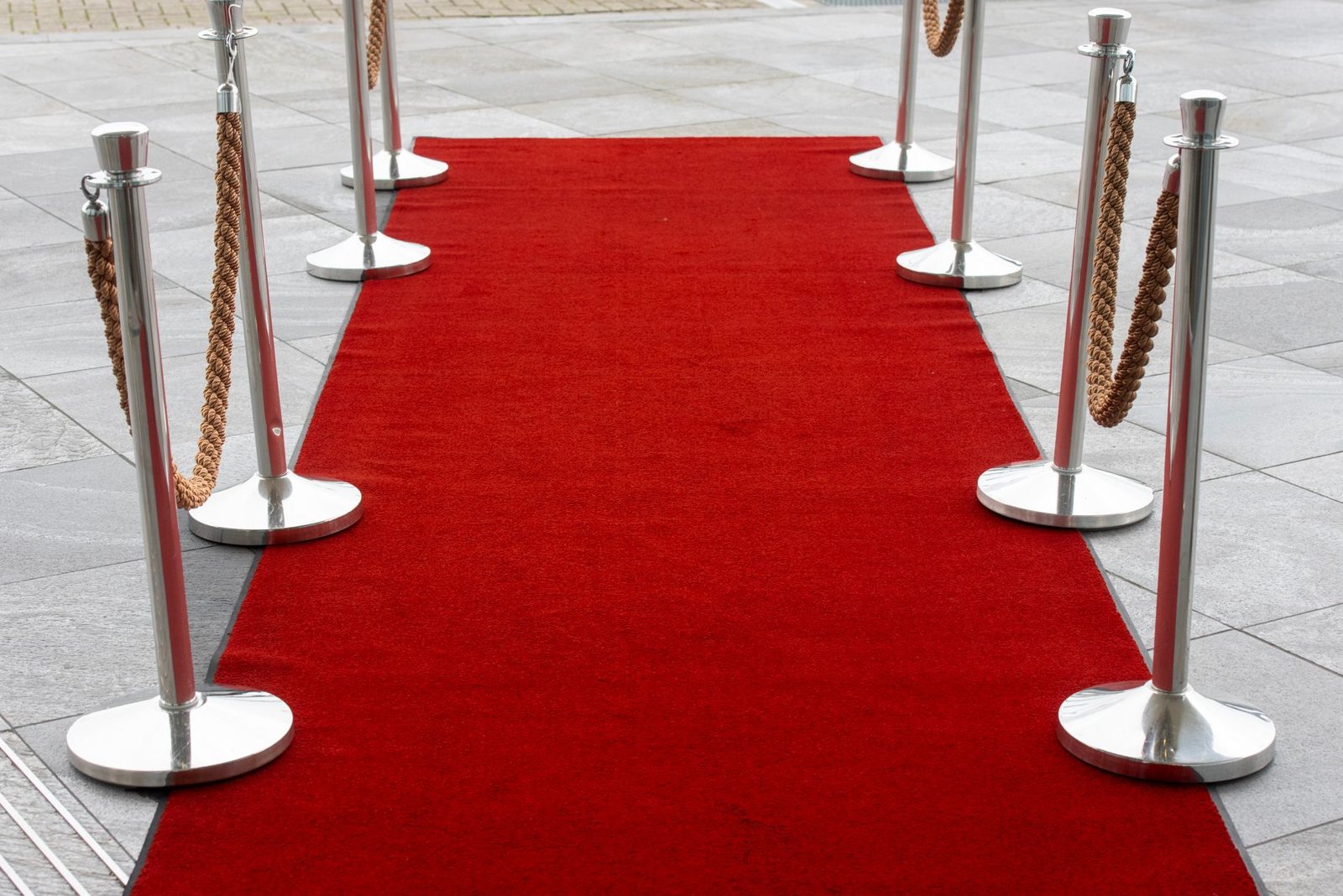 Entrada con alfombra roja y cordones en una calle, imagen ilustrativa del estreno de Artificial de Luca Guadagnino
