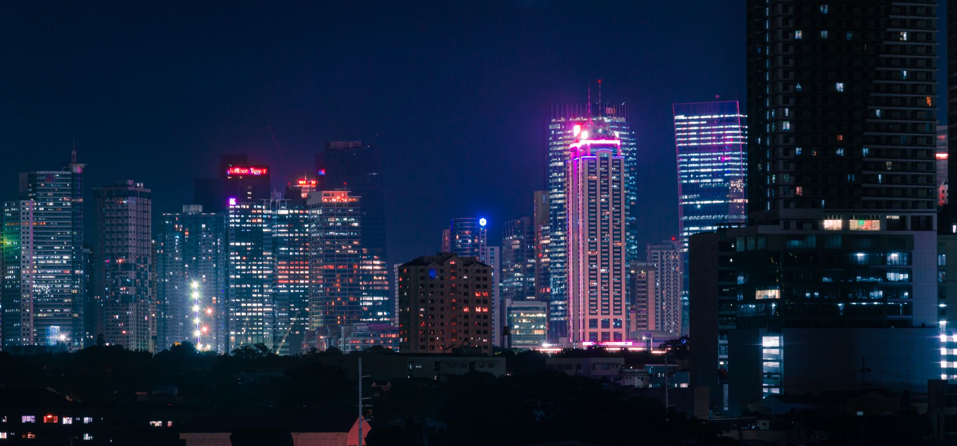 Paisaje urbano nocturno con rascacielos iluminados con neón, imagen ilustrativa del Los Ángeles futurista de Blade Runner 2099