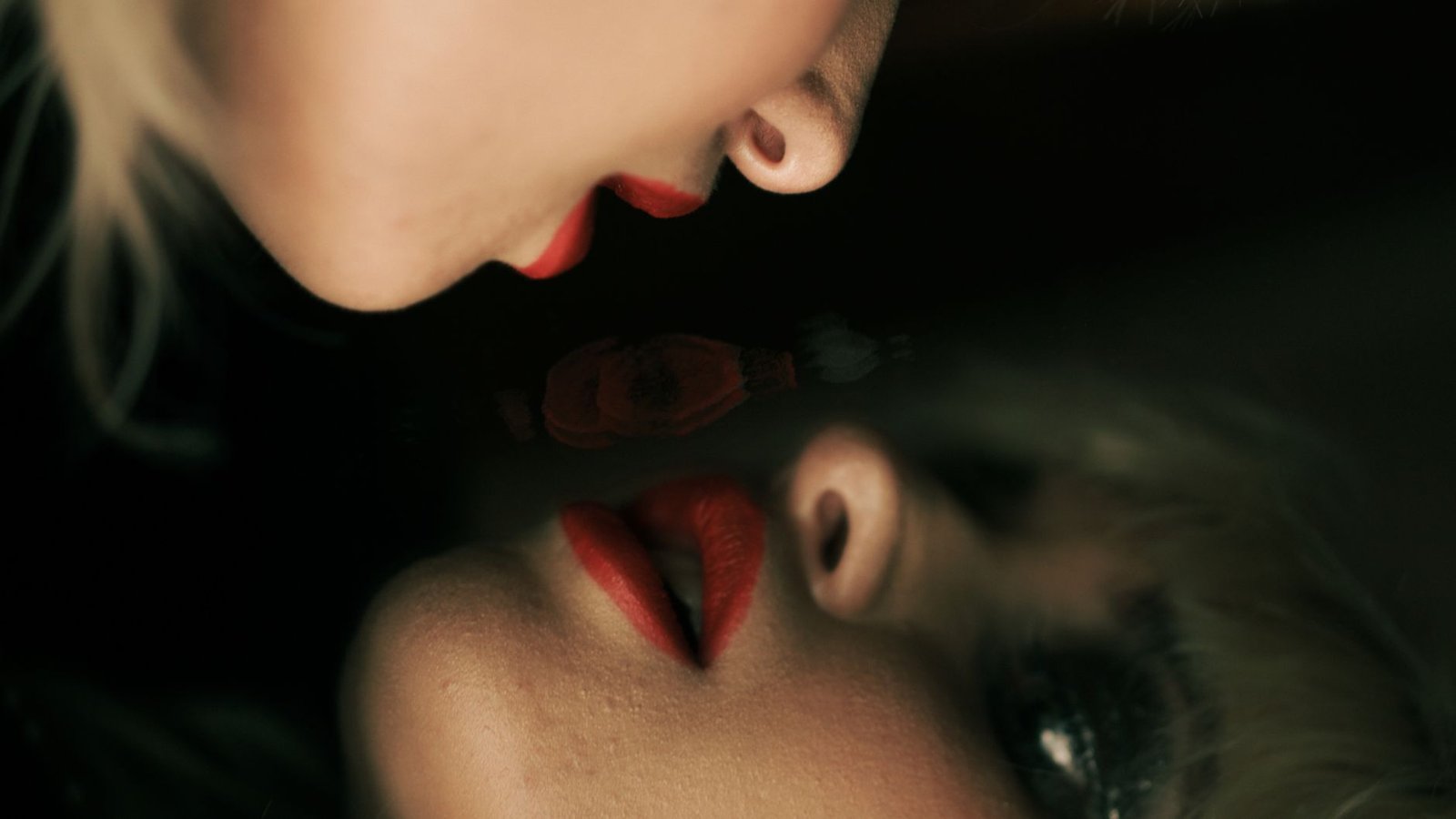 Retrato artístico reflejado en un espejo con labios rojos, imagen ilustrativa para Jennifer's Body 2