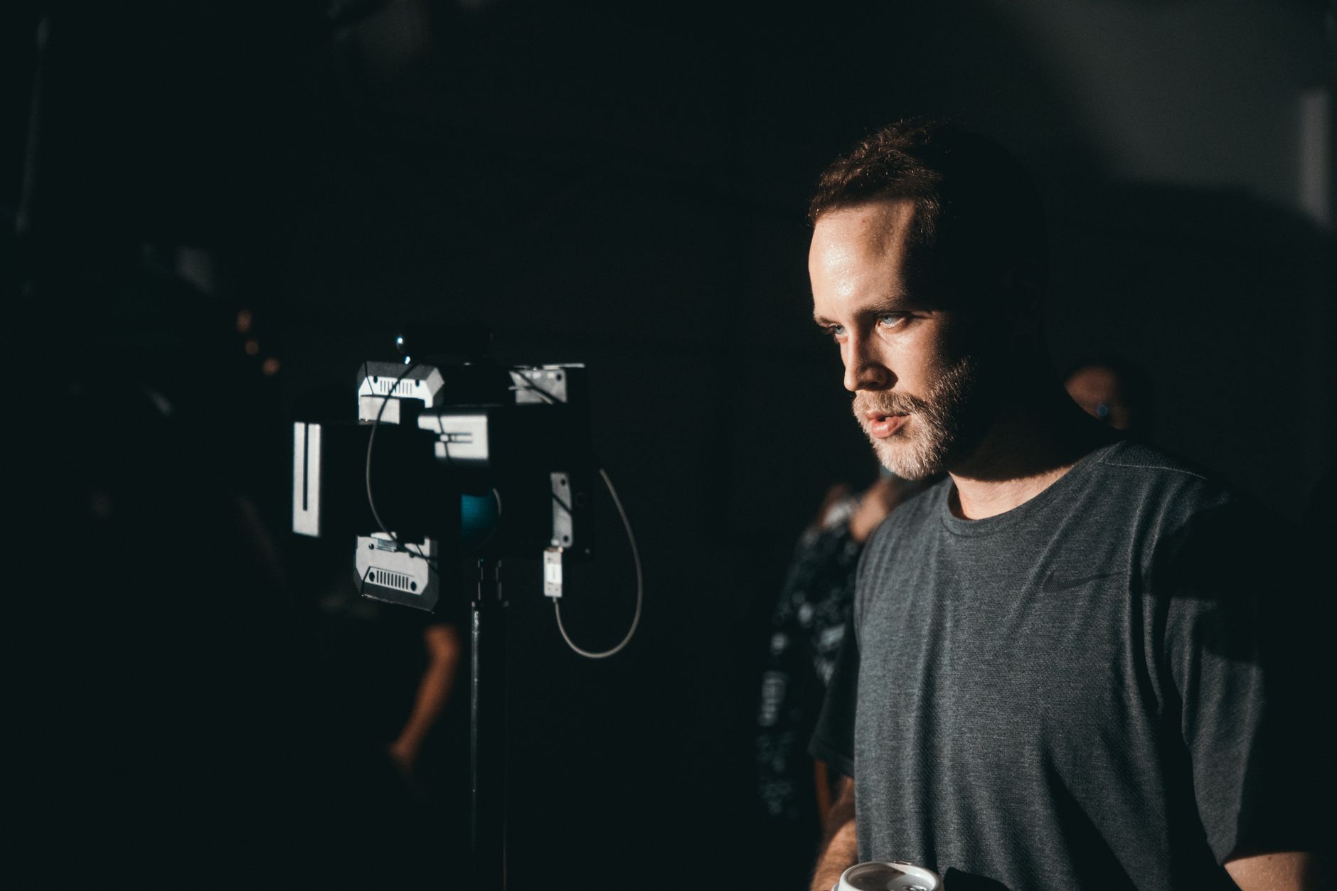 Camarógrafo trabajando con su equipo en un set de cine con poca luz