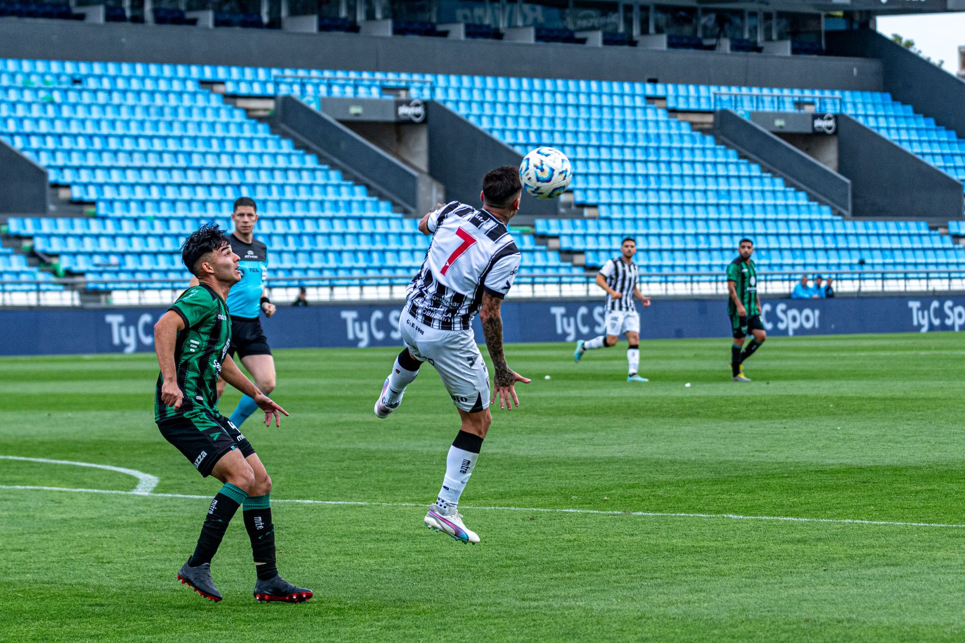 Partido de fútbol con jugadores en movimiento dentro de un estadio, como los del equipo de Ted Lasso